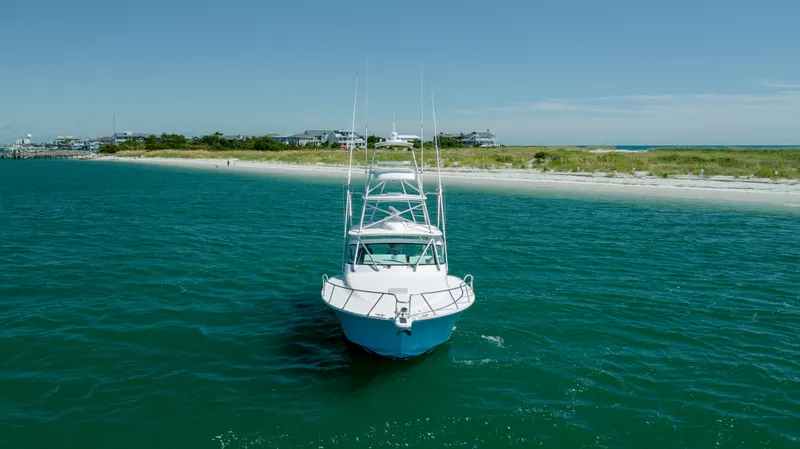 Slide: The Image of 2019 Albemarle 410 Express Fisherman boat on clear blue water near sandy shore. - 7