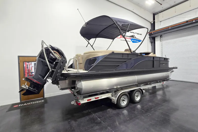 Slide: The Image of 2026 Bennington 23 L pontoon boat on trailer in indoor showroom. - 3