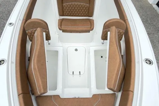 Slide: The Image of 2026 Sea Hunt Ultra 255 SE boat interior with tan cushioned seating and storage compartments. - 28