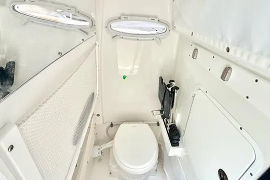 Slide: The Image of 2026 Sea Hunt Ultra 255 SE boat interior with compact marine toilet and storage. - 31