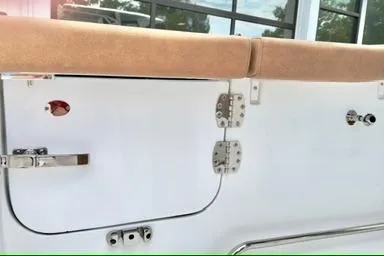 Slide: The Image of 2026 Sea Hunt Ultra 255 SE boat interior detail with beige upholstery and stainless steel fittings. - 6