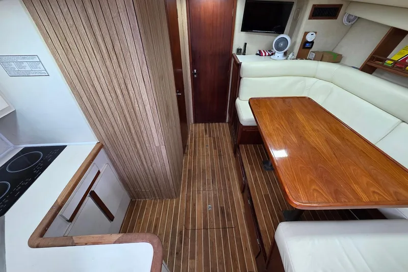 Slide: The Image of Interior of 1990 Topaz 39 Royale yacht with wooden flooring and dining area. - 11