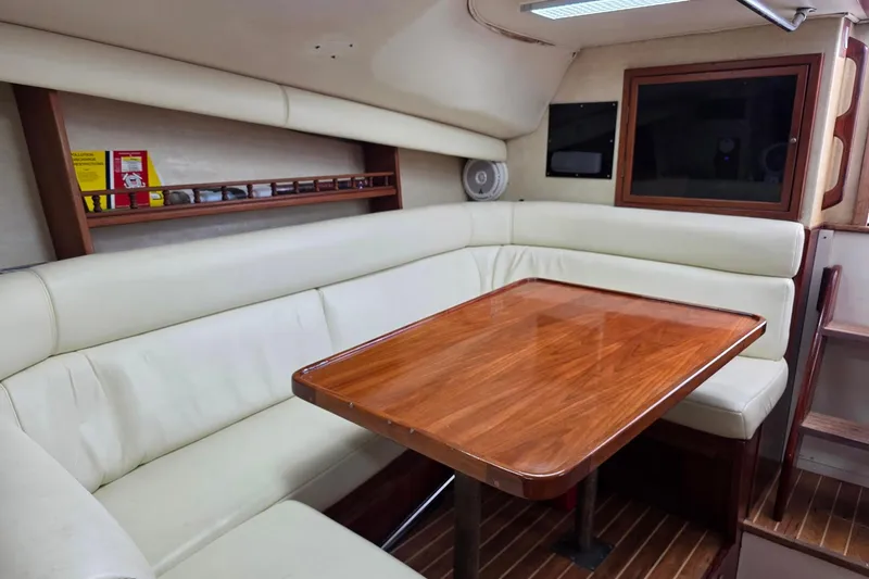 Slide: The Image of Interior of 1990 Topaz 39 Royale yacht with wooden table and cream seating. - 12