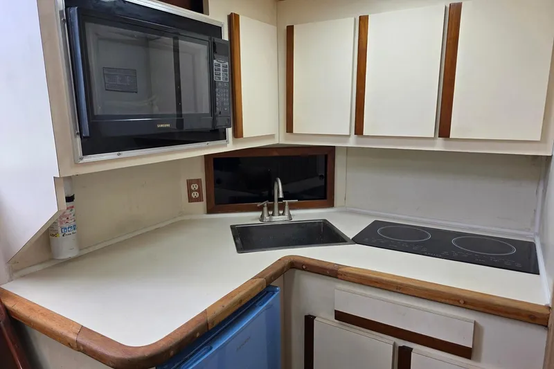Slide: The Image of Compact kitchen in a 1990 Topaz 39 Royale boat with microwave, sink, and stovetop. - 13