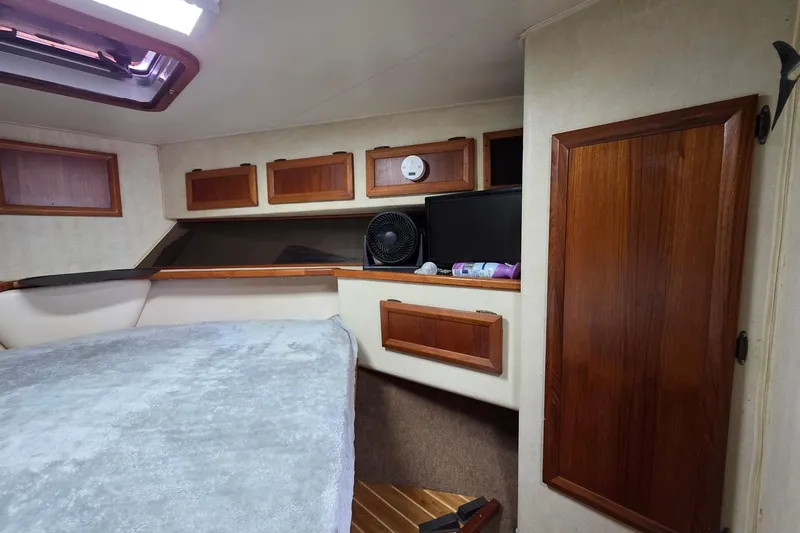 Slide: The Image of Interior of a 1990 Topaz 39 Royale boat with wooden cabinets and a cozy bed. - 17