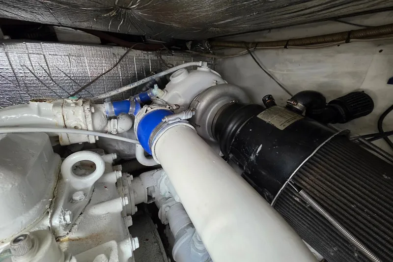 Slide: The Image of Engine compartment of a 1990 Topaz 39 Royale boat, featuring mechanical components and hoses. - 19
