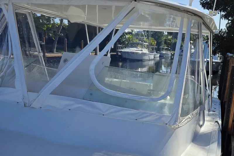 Slide: The Image of 1990 Topaz 39 Royale boat docked in a marina with clear canopy. - 2