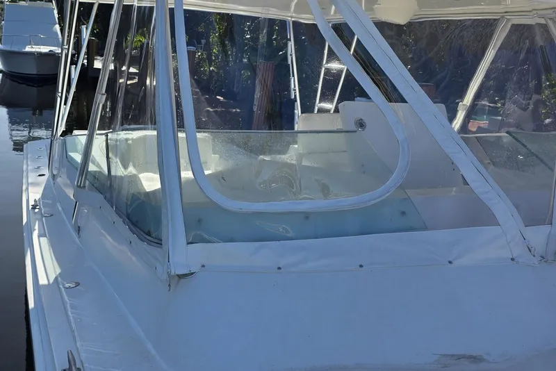 Slide: The Image of 1990 Topaz 39 Royale boat with clear enclosure, docked in a marina. - 3