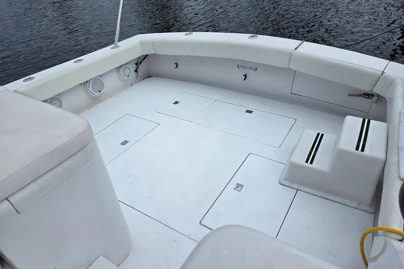 Slide: The Image of Spacious deck of 1990 Topaz 39 Royale boat, featuring white seating and storage compartments. - 5