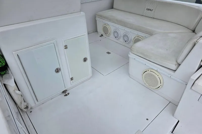 Slide: The Image of Interior of a 1990 Topaz 39 Royale boat with white seating and storage compartments. - 8