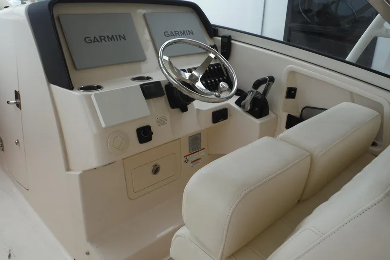 Slide: The Image of Helm of 2019 Grady-White Freedom 325 boat with Garmin displays and steering wheel. - 21