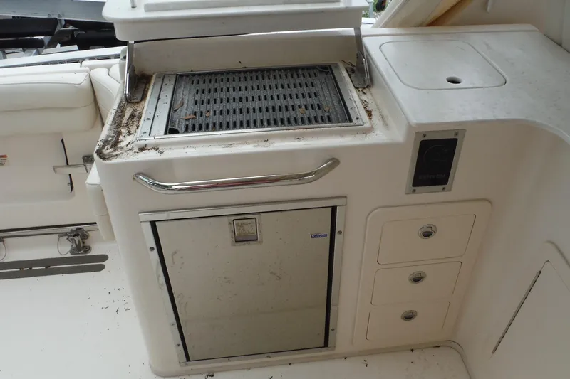 Slide: The Image of Outdoor grill and storage area on a 2019 Grady-White Freedom 325 boat. - 24