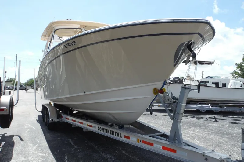 Slide: The Image of 2019 Grady-White Freedom 325 boat on trailer, parked outdoors under clear sky. - 3