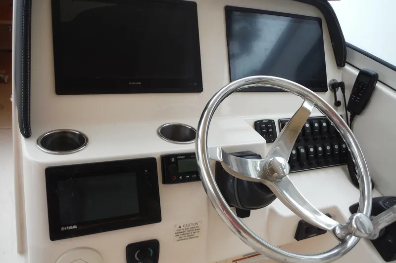 Slide: The Image of 2019 Grady-White Freedom 325 boat dashboard with steering wheel and electronic displays. - 30