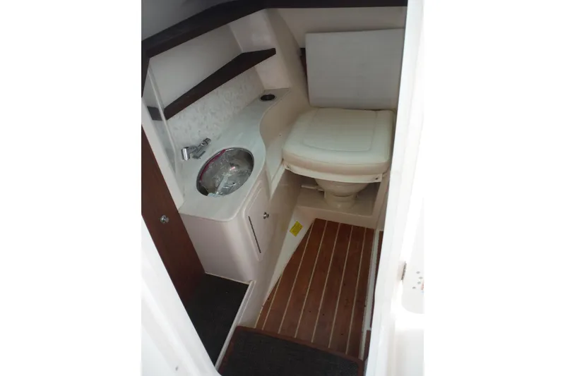 Slide: The Image of 2019 Grady-White Freedom 325 boat interior with compact bathroom, sink, and wooden flooring. - 33