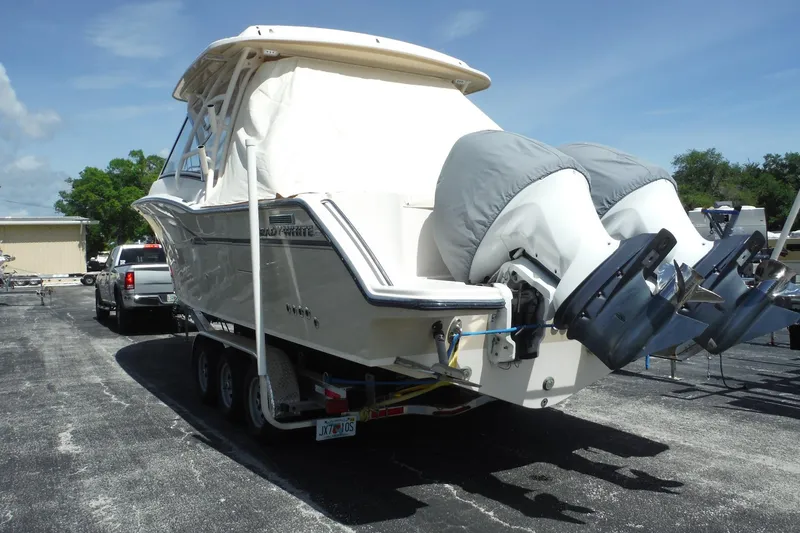 Slide: The Image of 2019 Grady-White Freedom 325 boat on trailer, dual engines covered, parked outdoors. - 4