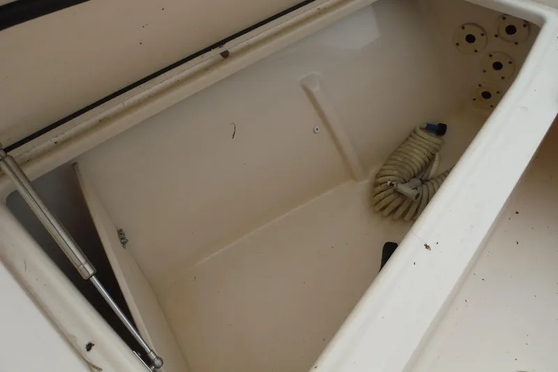 Slide: The Image of Storage compartment of 2019 Grady-White Freedom 325 boat with coiled hose. - 44