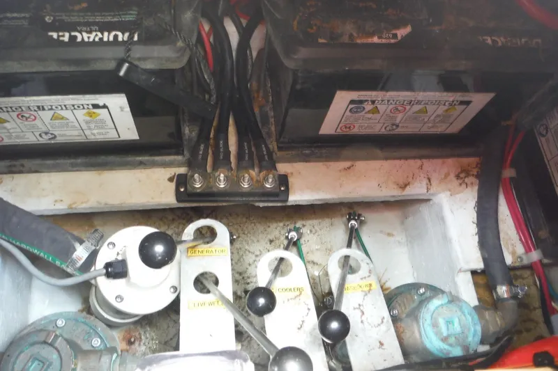 Slide: The Image of Battery compartment of a 2019 Grady-White Freedom 325 boat, showing wiring and switches. - 53
