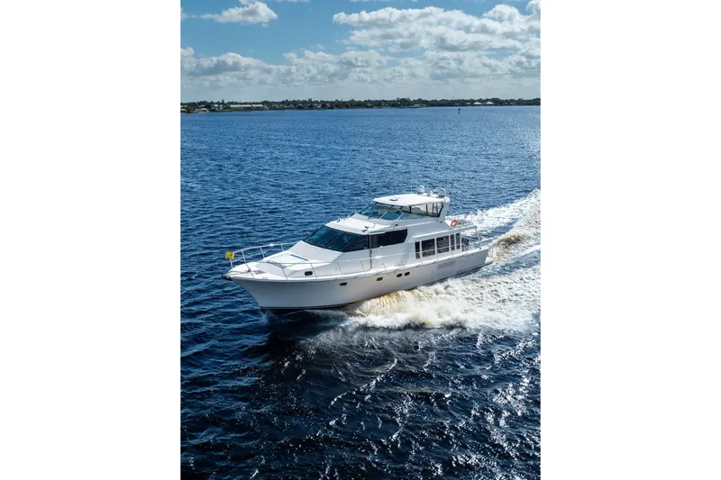 Slide: The Image of 2009 Pacific Mariner 65 Motoryacht cruising on open water under a partly cloudy sky. - 10