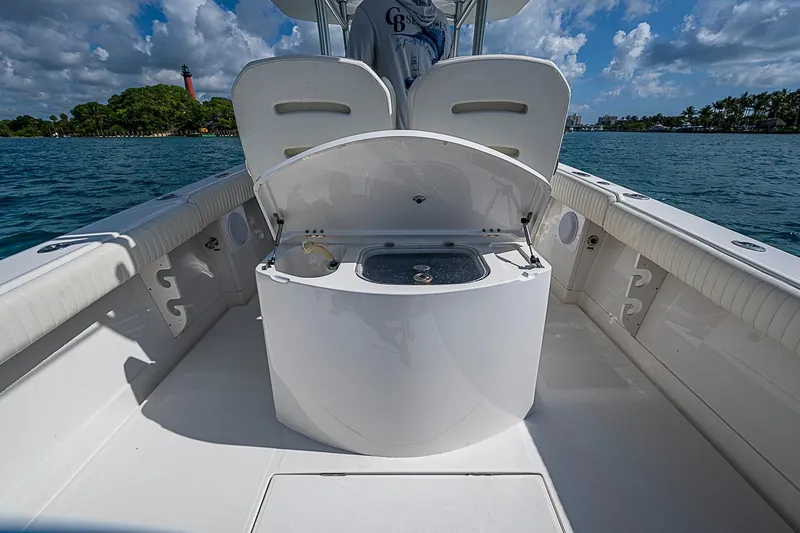 Slide: The Image of 2007 Jupiter 29 FS boat interior with open storage, ocean view, and lighthouse in background. - 12