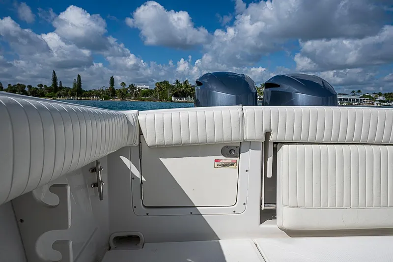 Slide: The Image of 2007 Jupiter 29 FS boat interior with white seating and dual engines, under a blue sky. - 13
