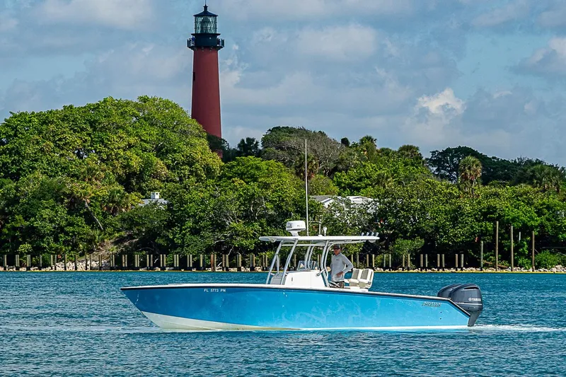Slide: The Image of Blue 2007 Jupiter 29 FS boat cruising near a lighthouse and lush greenery. - 20
