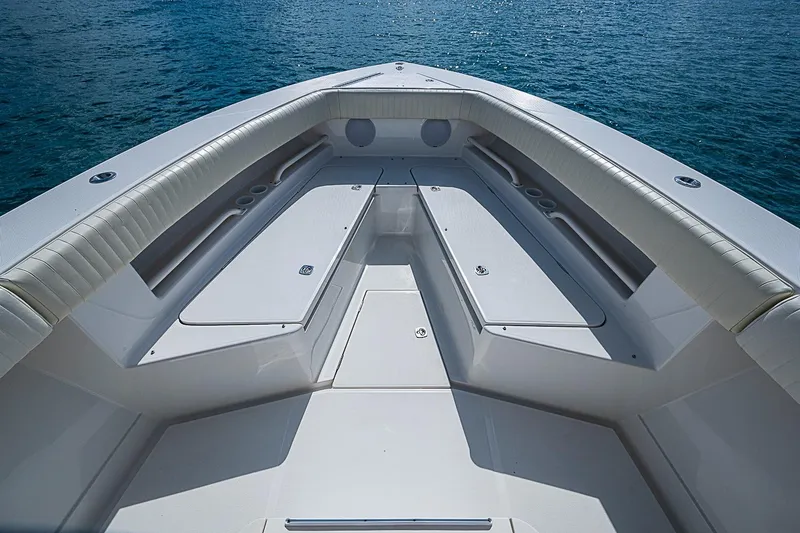 Slide: The Image of 2007 Jupiter 29 FS boat interior with cushioned seating and storage, on calm blue water. - 4