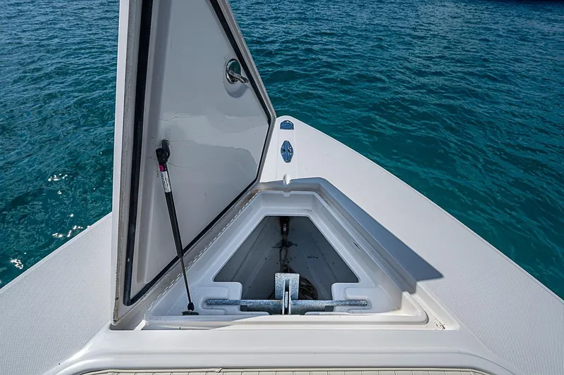 Slide: The Image of Open anchor hatch on 2007 Jupiter 29 FS boat, floating on clear blue water. - 6