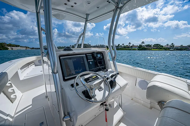 Slide: The Image of 2007 Jupiter 29 FS boat interior with steering wheel and navigation system on a sunny day. - 8