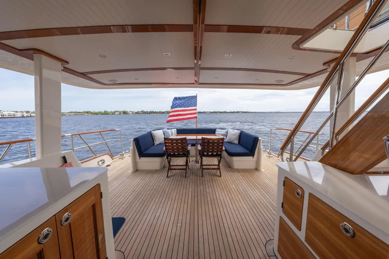 Slide: The Image of Luxurious 2022 Hunt Ocean 76EP yacht deck with seating, American flag, and scenic water view. - 20
