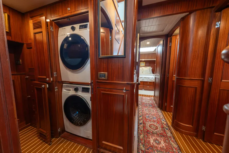 Slide: The Image of Laundry area in 2022 Hunt Ocean 76EP yacht with wood paneling and hallway view. - 48