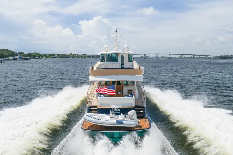 Slide: The Image of 2022 Hunt Yachts Ocean 76EP cruising on open water, rear view with American flag. - 5