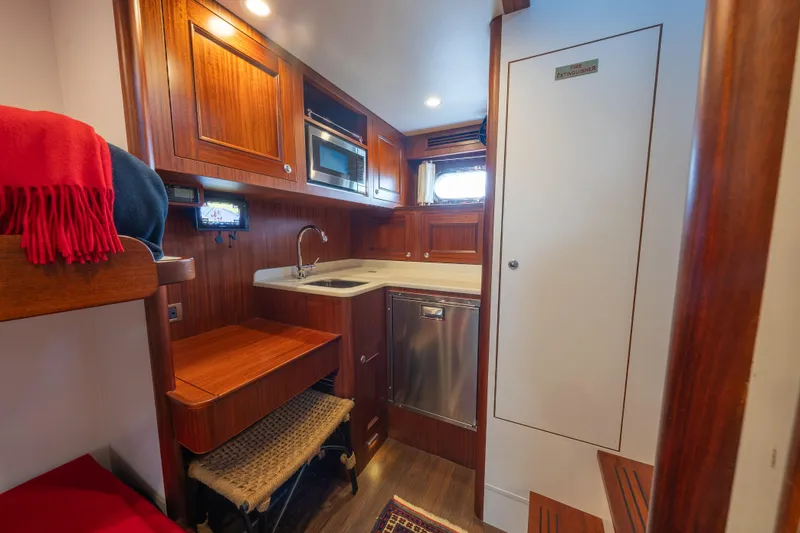 Slide: The Image of Luxurious 2022 Hunt Ocean 76EP yacht interior with kitchenette and wooden cabinetry. - 52
