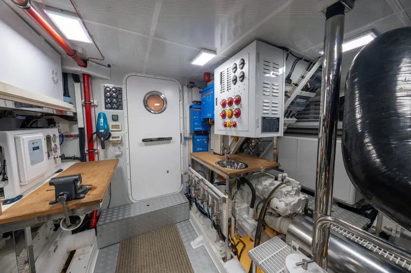 Slide: The Image of Engine room of 2022 Hunt Yachts Ocean 76EP, featuring control panels and equipment. - 55