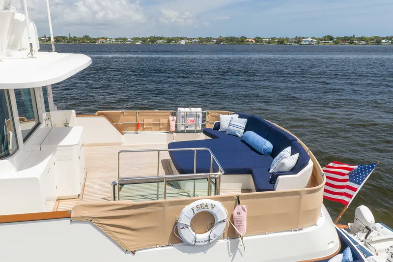 Slide: The Image of Luxury deck of 2022 Hunt Ocean 76EP yacht with seating and American flag. - 8
