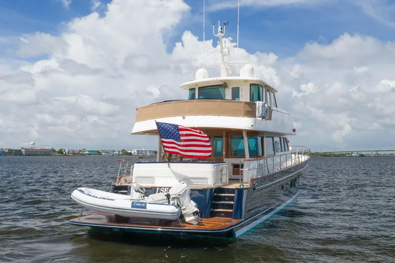 Slide: The Image of 2022 Hunt Yachts Ocean 76EP on water, American flag, clear sky background. - 9