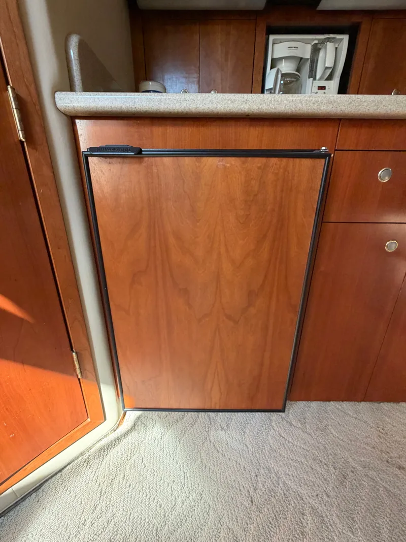 Slide: The Image of Kitchen area of 2005 Rampage 33 Express with wooden cabinets. - 33