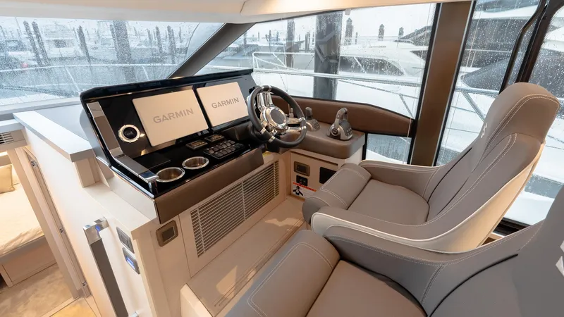 Slide: The Image of Luxurious 2023 Prestige 520S yacht helm with Garmin navigation displays and plush seating. - 13
