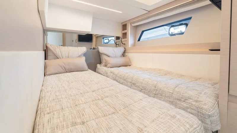 Slide: The Image of 2023 Prestige 520S yacht cabin with twin beds and modern interior design. - 21