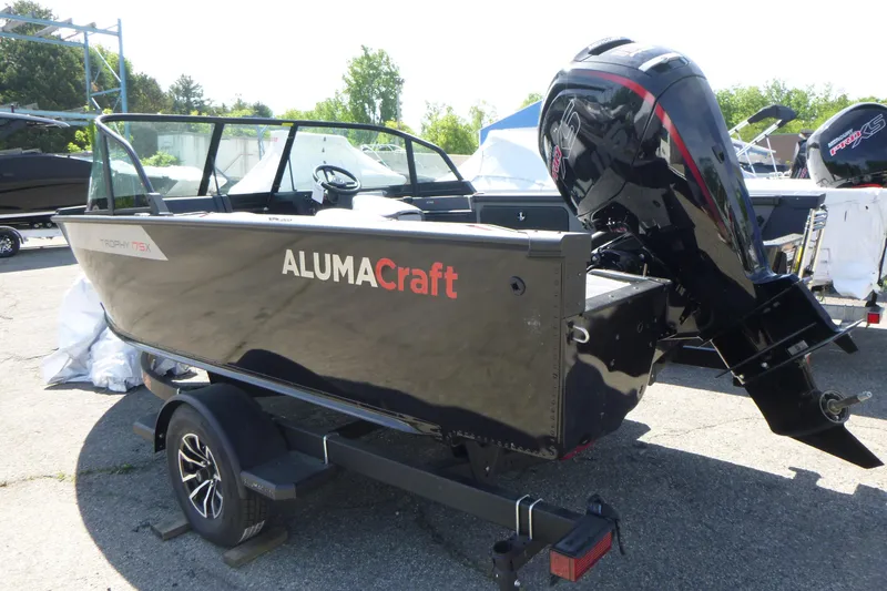 Slide: The Image of 2025 Alumacraft Trophy 175X Sport boat on trailer, featuring sleek black design and powerful outboard motor. - 3