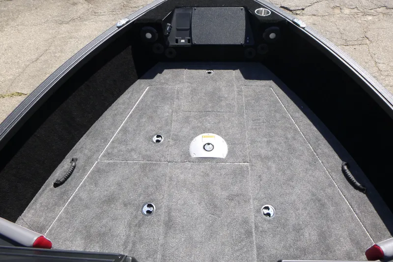 Slide: The Image of 2025 Alumacraft Trophy 175X Sport boat interior with carpeted deck and storage compartments. - 7