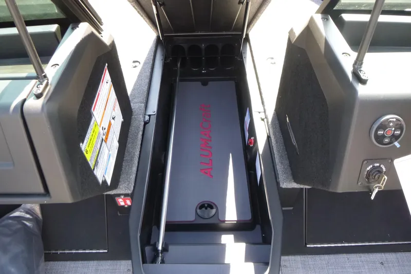 Slide: The Image of 2025 Alumacraft Trophy 175X Sport boat interior with storage compartment and control panel. - 8