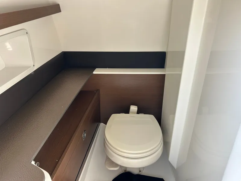 Slide: The Image of Interior view of a boat cabin with a toilet and storage space. - 21