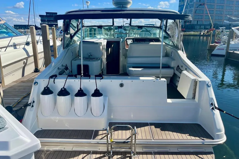 Slide: The Image of 1994 Sea Ray 370 Express Cruiser docked at marina, rear view with seating area. - 10