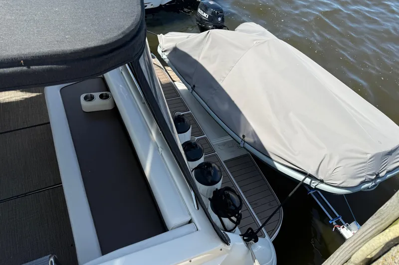 Slide: The Image of 1994 Sea Ray 370 Express Cruiser with covered dinghy, docked on calm water. - 13