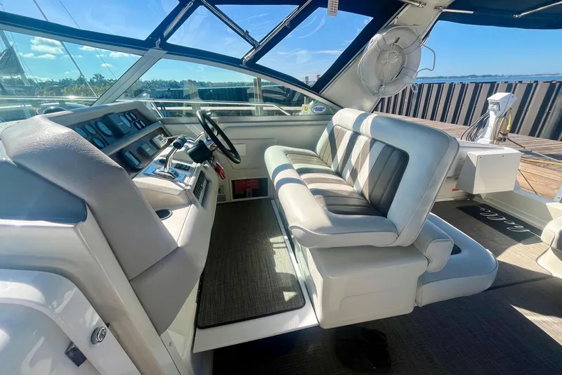 Slide: The Image of 1994 Sea Ray 370 Express Cruiser helm with plush seating and modern controls. - 15