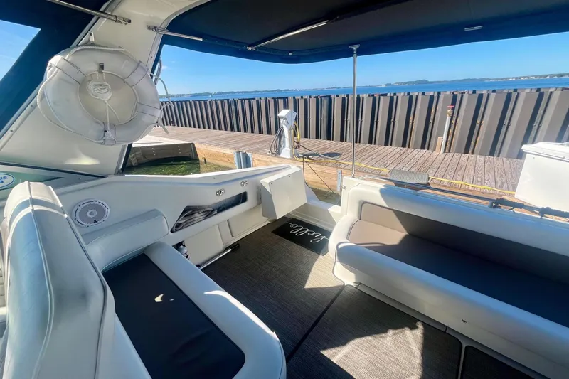 Slide: The Image of 1994 Sea Ray 370 Express Cruiser interior with seating, docked by the water. - 18