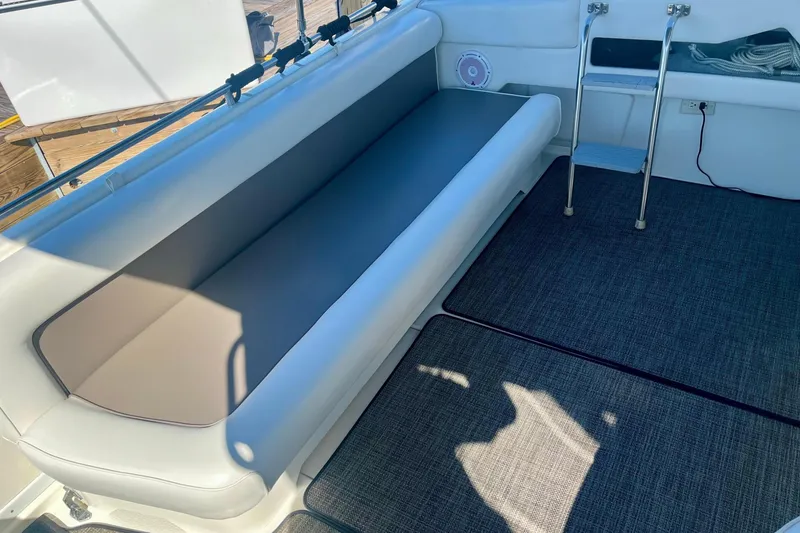 Slide: The Image of 1994 Sea Ray 370 Express Cruiser interior with cushioned seating and ladder. - 19