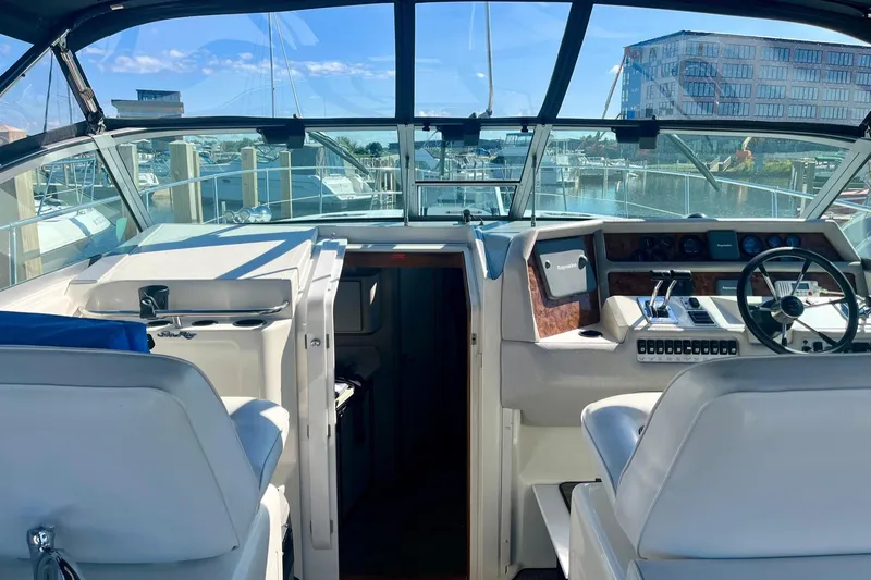 Slide: The Image of 1994 Sea Ray 370 Express Cruiser cockpit with steering wheel and controls, docked at marina. - 20