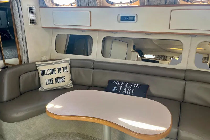 Slide: The Image of Interior of 1994 Sea Ray 370 Express Cruiser with cozy seating and decorative pillows. - 22